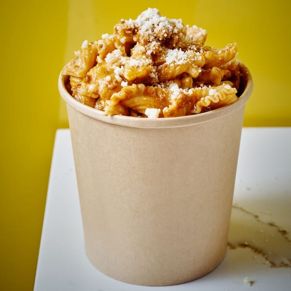 Pasta Lab NYC's Italian pasta with sauce and grated cheese, served in a brown paper cup.